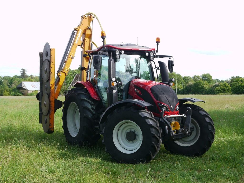 Tracteur rouge de SARL Guignard Élagage équipé d'un lamier à scies